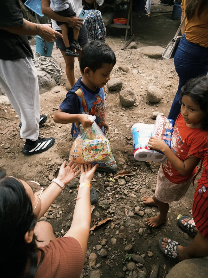Voluntaria entregando bolsas de víveres a niños de la comunidad