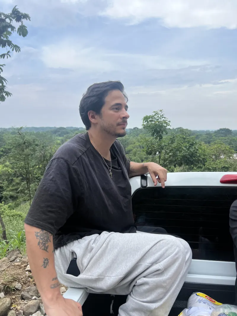 Voluntario sentado en el pickup con el paisaje de Guatemala al fondo