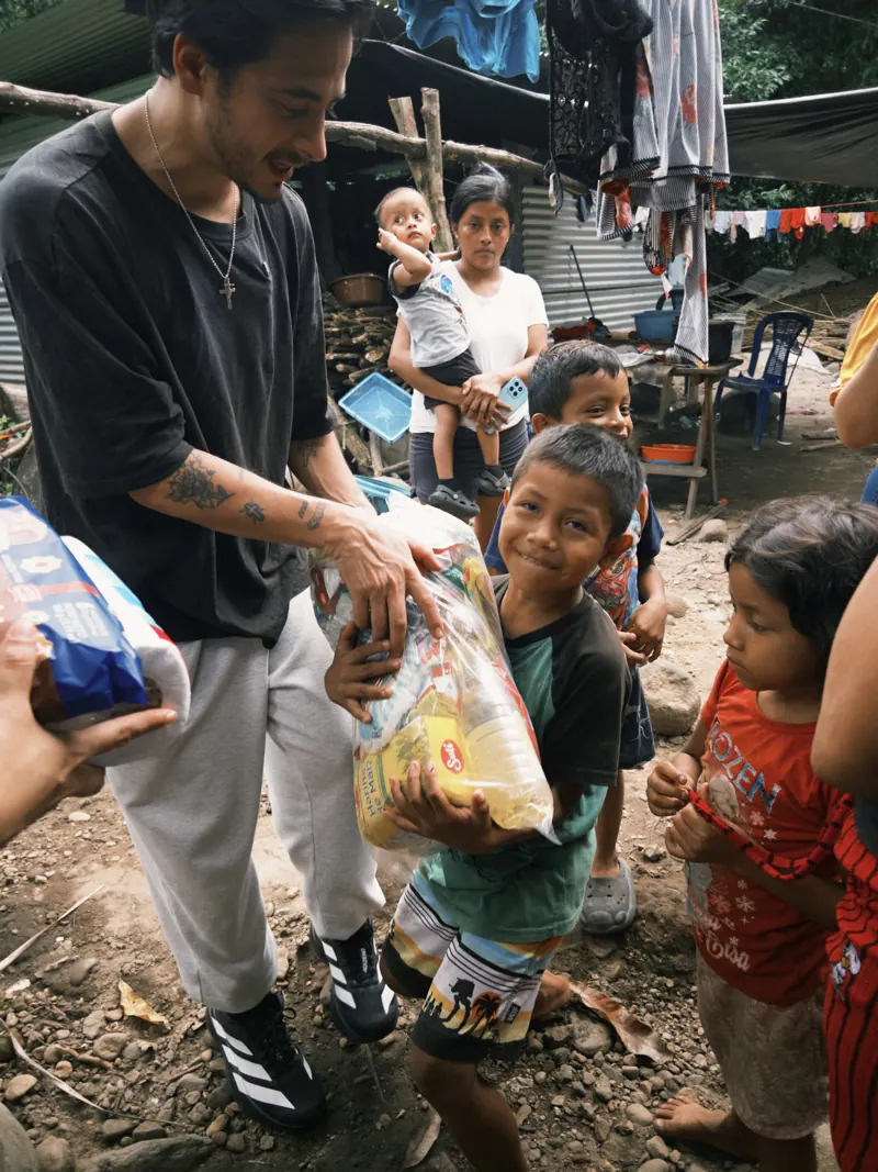 Voluntario sonriendo mientras entrega víveres a una familia